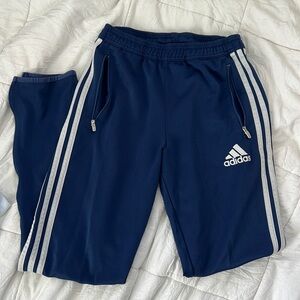 Blue adidas sweatpants with classic three strips along the legs